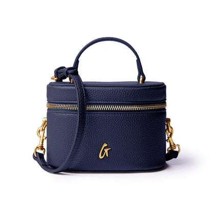 Navy mini pebble vanity bag with gold zipper and logo, featuring a top handle and detachable strap for versatility.
