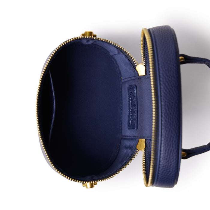 Open navy mini pebble vanity bag with gold zipper, showing spacious interior and organized compartments.