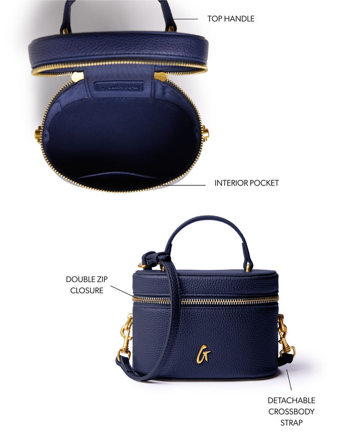 Navy mini pebble vanity bag with top handle, double zip closure, and detachable crossbody strap. Interior pocket included.