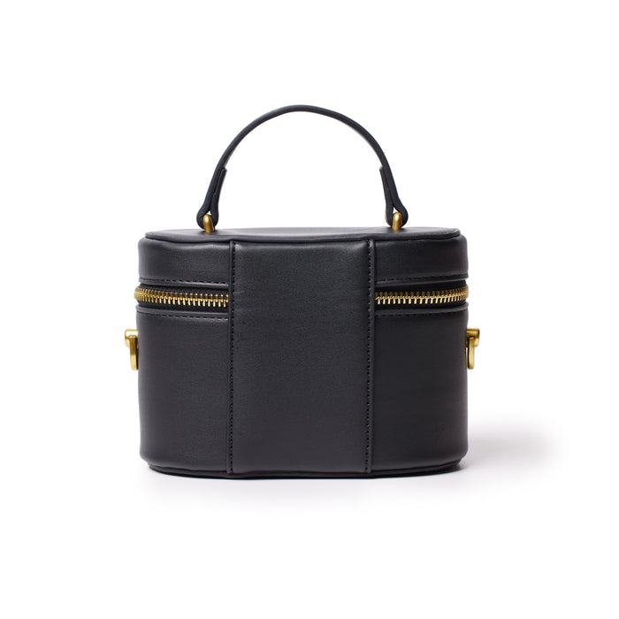 Small black vanity bag with a smooth finish, gold zipper, and handle, designed for stylish storage on the go.