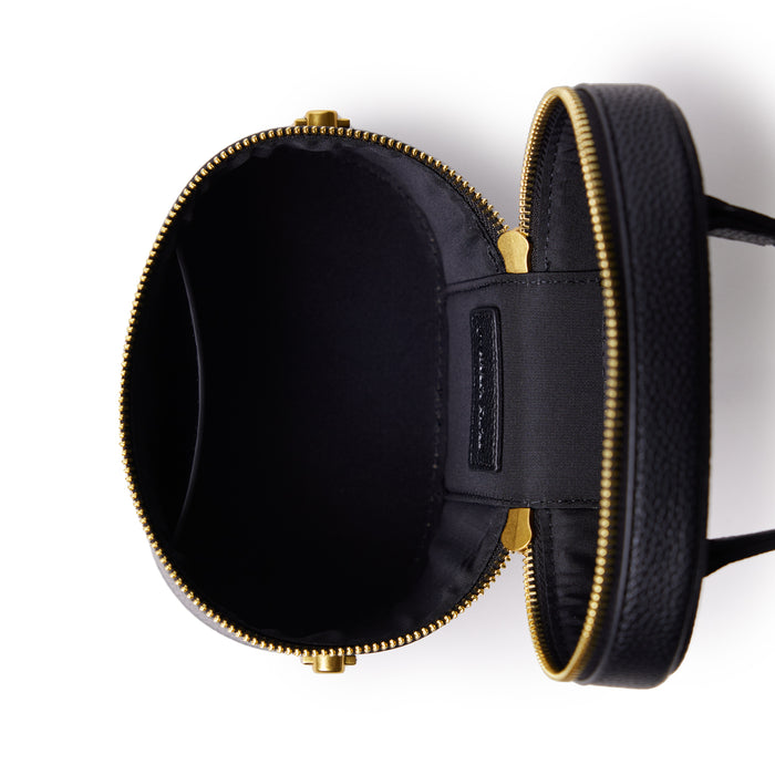Small black vanity bag with a smooth texture, gold zipper, and interior compartments for organizing essentials.