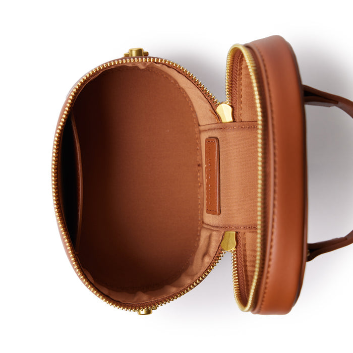 Open brown mini vanity bag with gold zipper, smooth finish, and spacious interior for makeup or accessories.