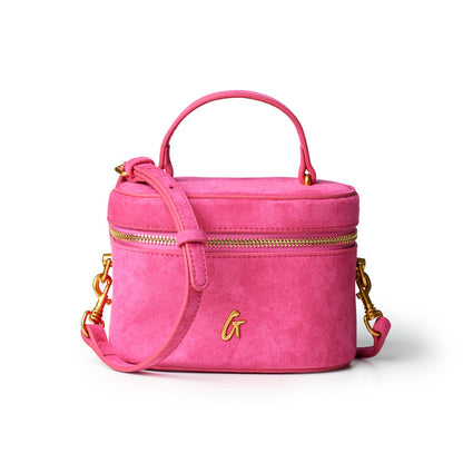 Hot pink mini suede vanity bag with gold zippers and a detachable shoulder strap, perfect for stylish organization.