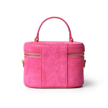 Hot pink mini suede vanity bag with dual zippers and a top handle, perfect for stylish storage on the go.