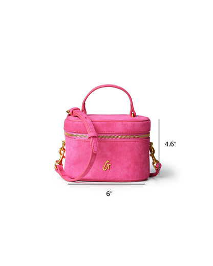 Hot pink mini suede vanity bag with gold accents, featuring a top handle and adjustable shoulder strap.