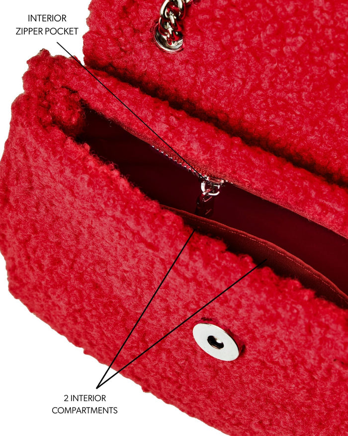 Red mini teddy flap bag featuring an interior zipper pocket and two compartments for organized storage.