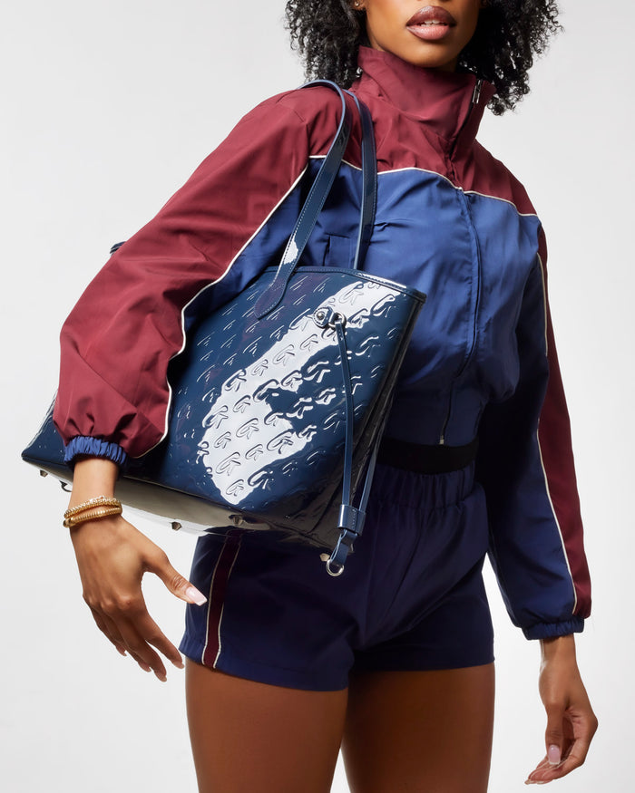 Monogram Glam Tote in Mirror Navy held by a model, showcasing its stylish design and spacious interior.