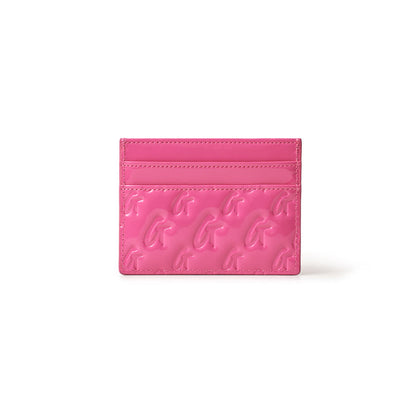 Pink mirror finish card holder with embossed gold "G" logo pattern and multiple card slots.