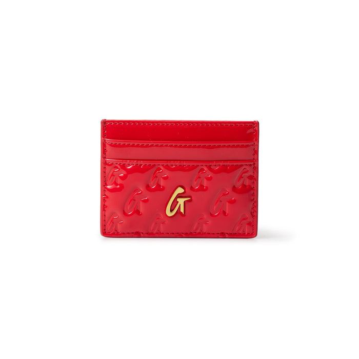 Red mirror finish card holder with gold "G" logo and embossed pattern, featuring multiple card slots.