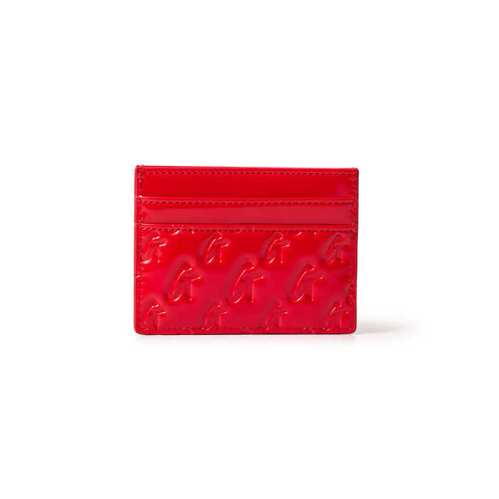 Red mirror-finish card holder with embossed G logo pattern and multiple card slots, part of the Monogram Gold collection.