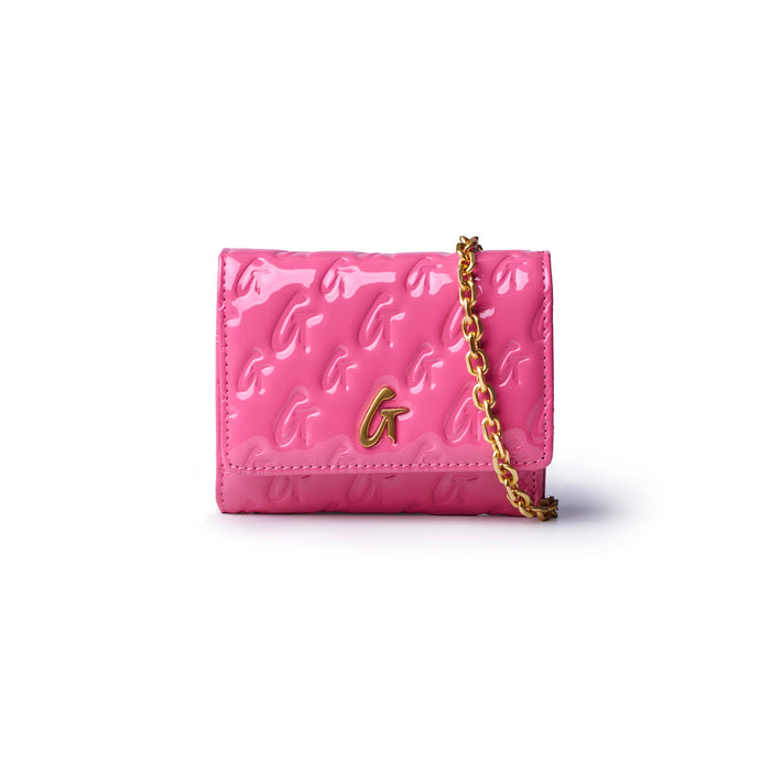 Hot pink compact wallet on chain with a glossy finish and gold monogram logo, perfect for stylish, affordable luxury.