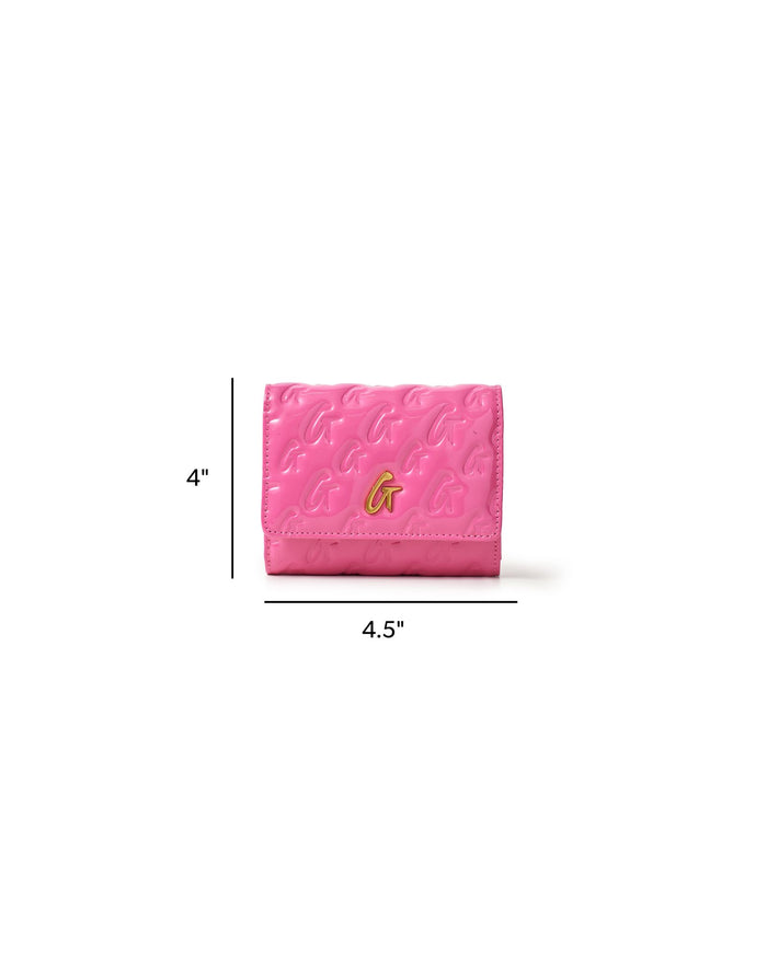 Hot pink compact wallet with embossed monogram design and gold logo, measuring 4 by 4.5 inches.
