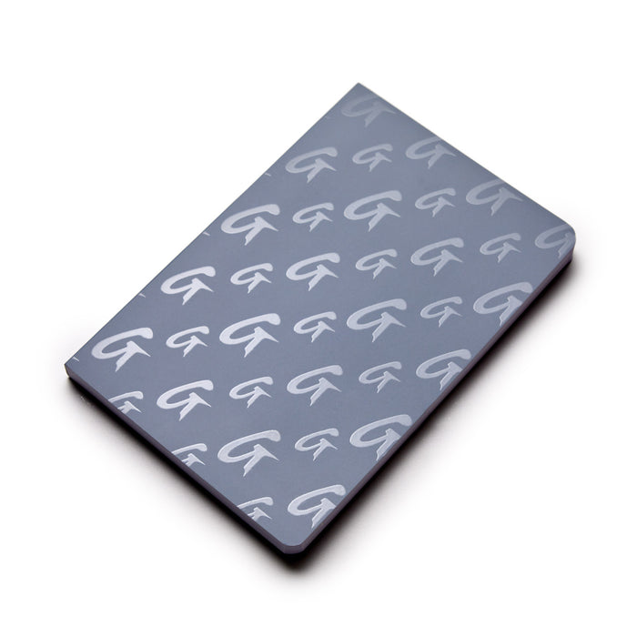 Gray monogram notebook with a repeating white "G" pattern on the cover, sleek and stylish for note-taking or journaling.