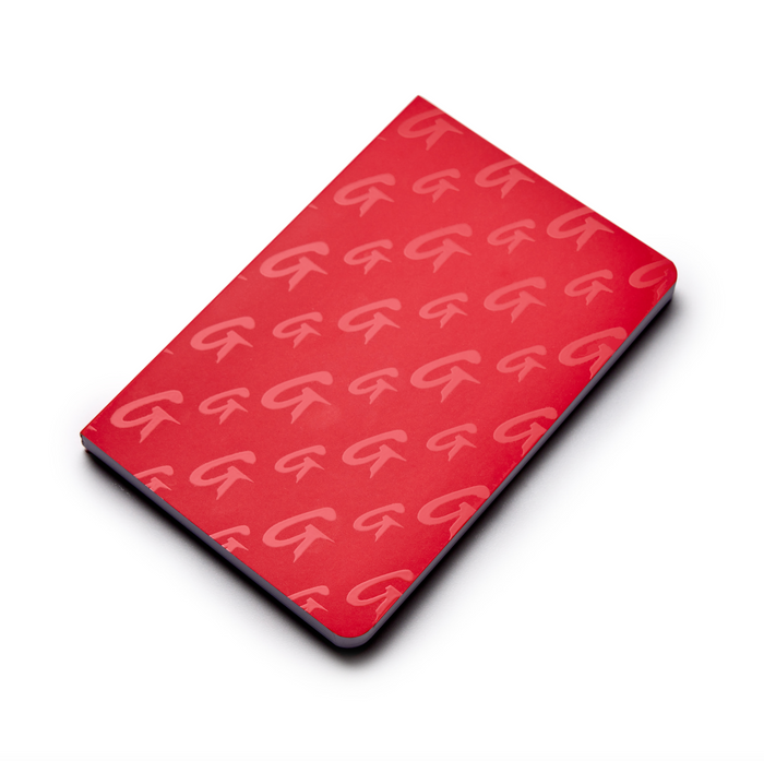Red monogram notebook with a repeating G logo pattern on the cover, slim design, and rounded edges.