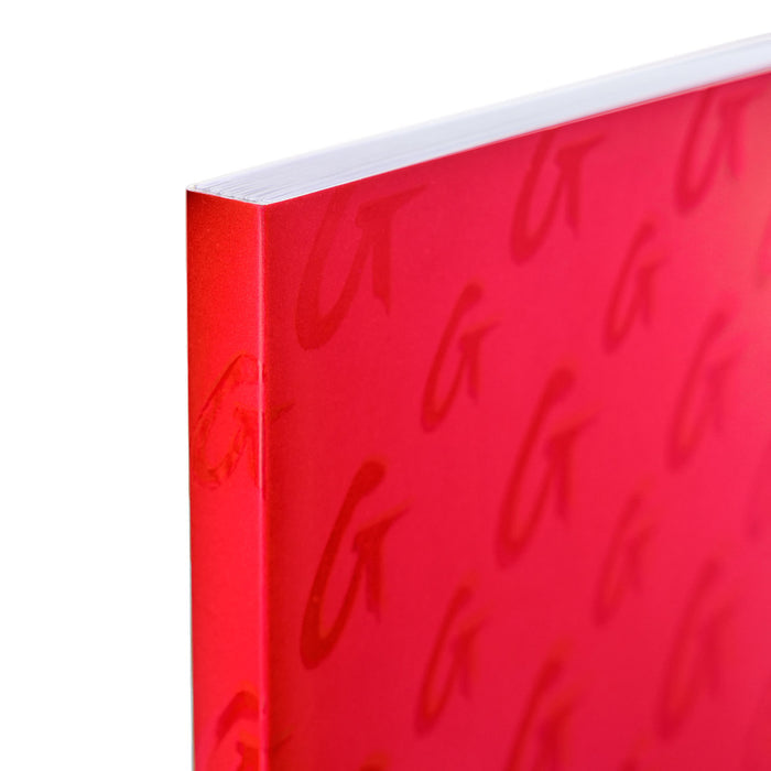 Red monogram notebook with a textured cover and subtle embossed letter pattern, featuring a clean, minimalist design.