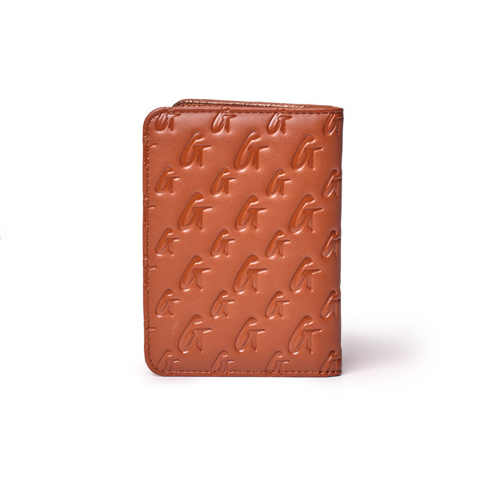 Brown monogram passport holder with embossed "G" pattern, compact design, and zipper closure at the top.