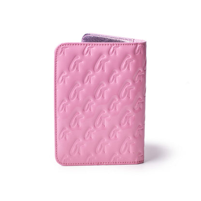 Mirror pink monogram passport holder with embossed G logo pattern and metallic interior, stylish travel accessory.
