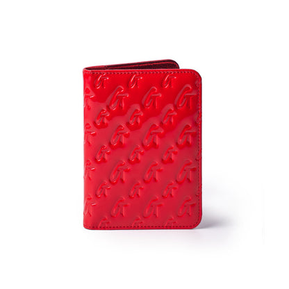 Red mirror finish monogram passport holder with embossed G pattern, compact design for travel accessories.