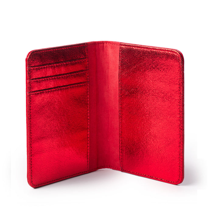 Red mirror finish monogram passport holder with card slots, open to show interior compartments.