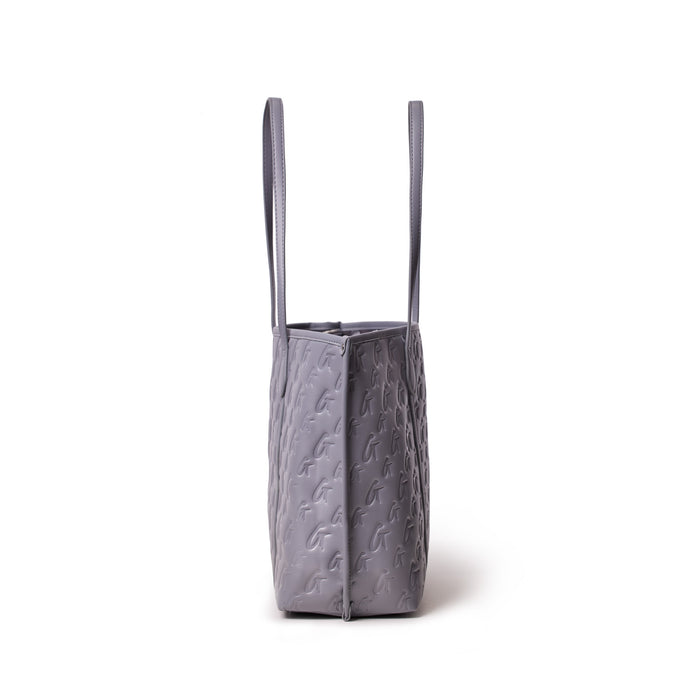 Gray Monogram Sleek Tote bag with embossed logo pattern and two shoulder straps, standing upright against a white background.