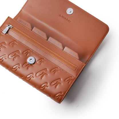 Brown travel wallet with embossed logo pattern, multiple labeled compartments, zipper pocket, and snap closure.