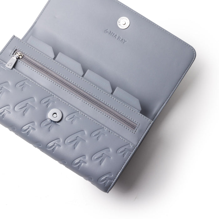 Gray monogram travel wallet with embossed logo pattern, zippered compartment, and interior card slots.