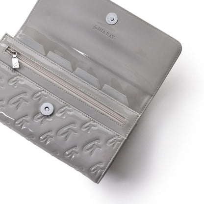 Mirror gray travel wallet with embossed G pattern, clear interior, zip pocket, and snap closure, designed by Mia Ray.