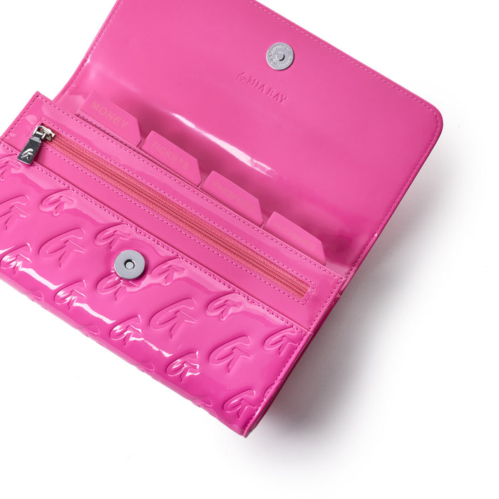 Pink monogram travel wallet with embossed G logo pattern, clear plastic interior, and multiple labeled compartments.
