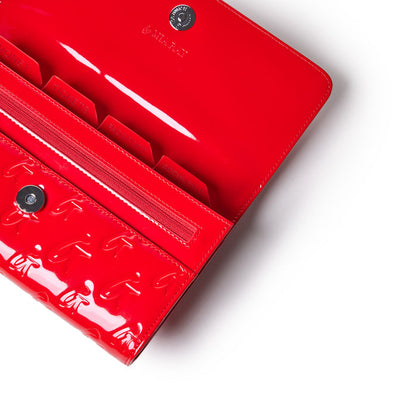 Red monogram travel wallet with a glossy finish, interior compartments for tickets, passports, and documents.