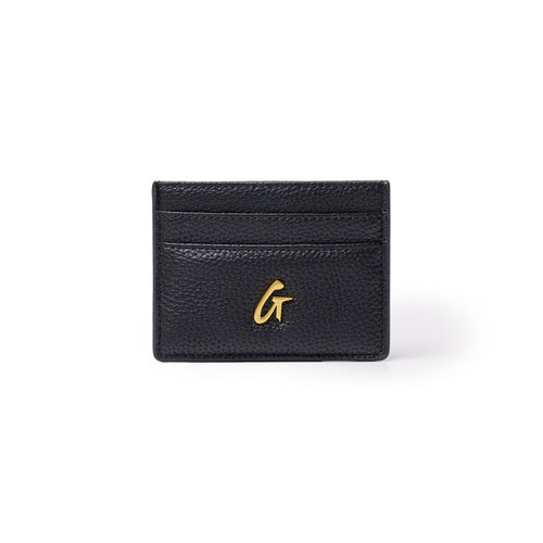Black pebble leather card holder with gold logo, featuring multiple card slots and compact design.