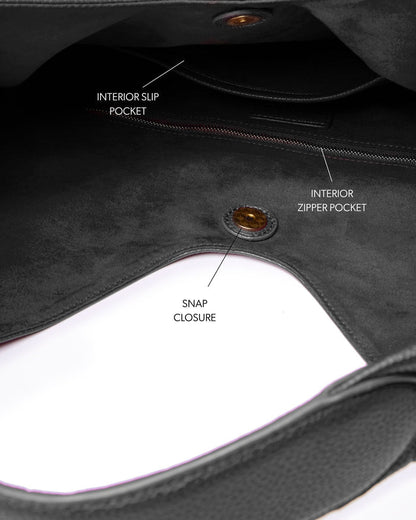 Interior view of the Pebble Hobo Shoulder Bag in black, featuring slip and zipper pockets, and a snap closure.