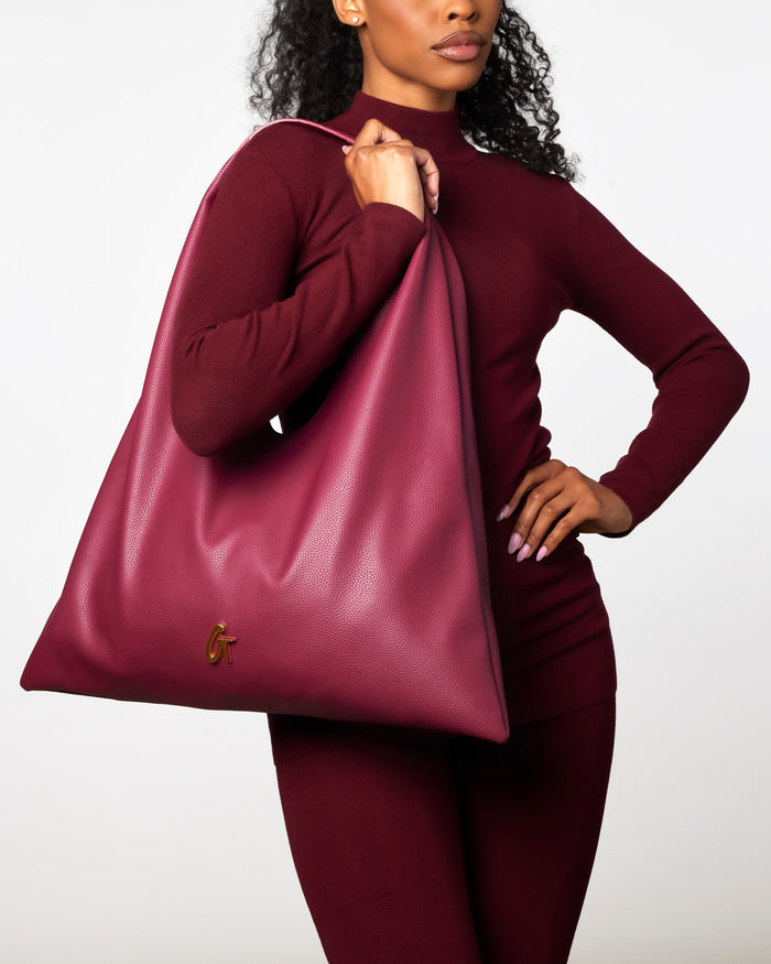 Burgundy Pebble Hobo Shoulder Bag held by a model in a matching outfit, showcasing its stylish and spacious design.