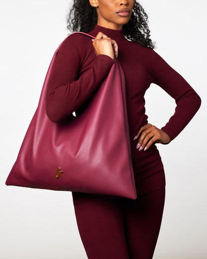 Burgundy Pebble Hobo Shoulder Bag held by a model in a matching outfit, showcasing its stylish and spacious design.