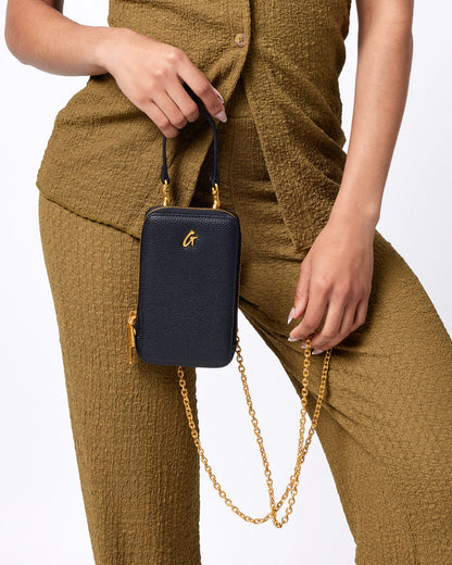 Black Pebble Phone Crossbody bag with gold chain and zipper, featuring a small gold logo on textured leather.