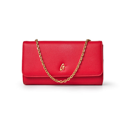 Red Pebble Travel Wallet with a gold chain and a gold "G" logo on the front, designed for travel and organization.