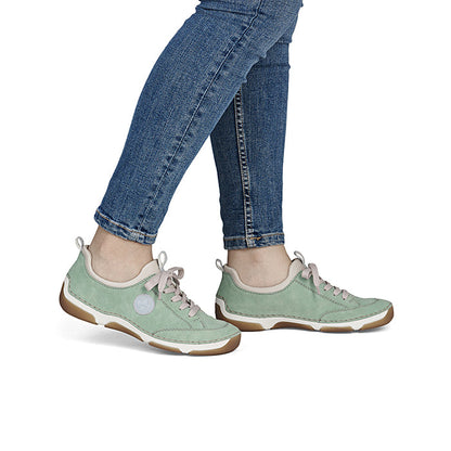 Green loafers on feet with lace-up design and gum sole