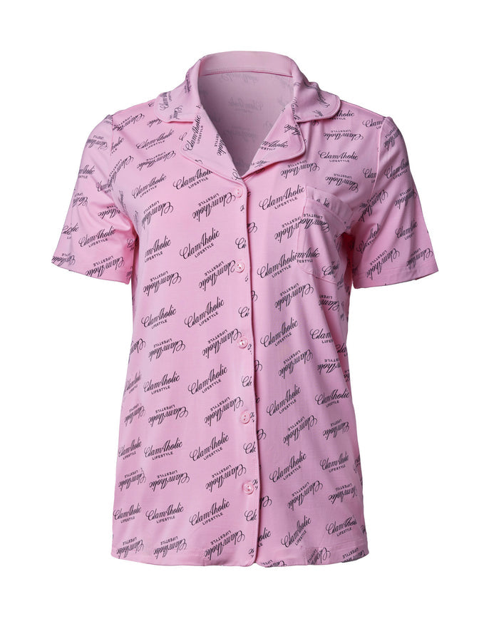 Light pink pajama short set featuring a button-up shirt with a repeating Glam-Aholic logo pattern. Ideal for stylish comfort.