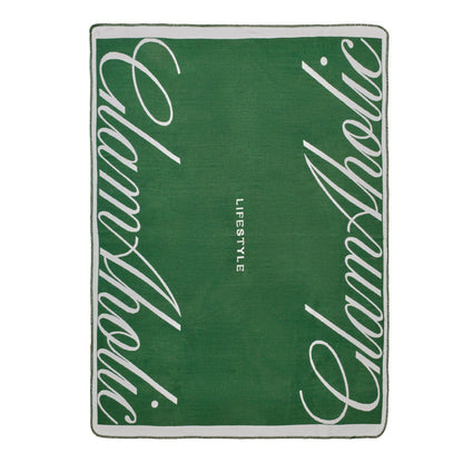 Green throw blanket featuring the Glam-Aholic logo and "LIFESTYLE" text, perfect for adding luxury to any space.