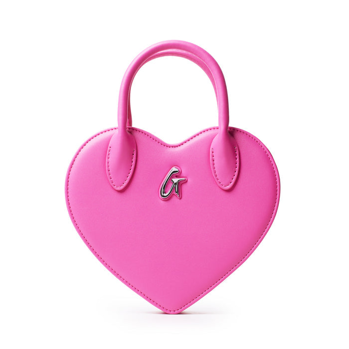 Pink heart-shaped bag with a silver "G" logo, featuring a top handle and stitched edges, stylish and playful accessory.