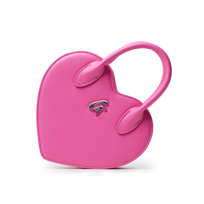 Pink heart-shaped bag with a small metal logo, featuring a top handle and smooth leather finish.
