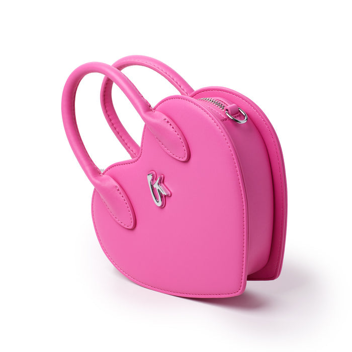 Pink heart-shaped bag with handles, silver logo, and zipper closure, designed for a stylish and playful accessory.