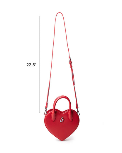 Red heart-shaped handbag with a top handle and adjustable shoulder strap, featuring a stylish logo detail.