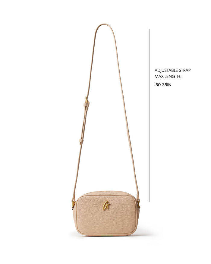 Nude pebble camera bag with adjustable strap, perfect for stylish on-the-go photography. Ideal for affordable luxury.
