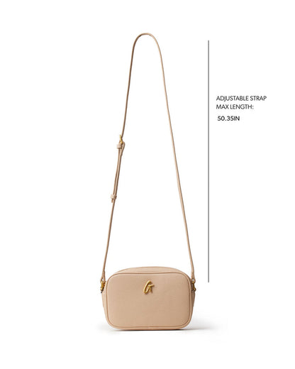 Nude pebble camera bag with adjustable strap, perfect for stylish on-the-go photography. Ideal for affordable luxury.