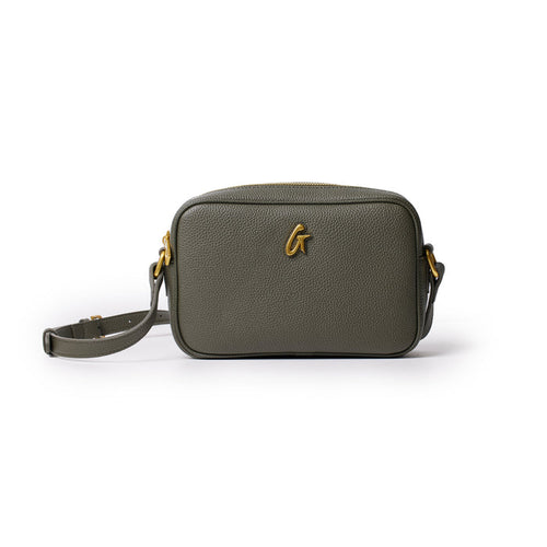 Olive green pebble leather camera bag with gold hardware and adjustable strap, designed for carrying photography essentials.
