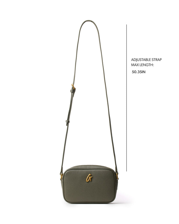 Olive green pebble camera bag with adjustable strap, featuring a sleek design and gold logo detail.