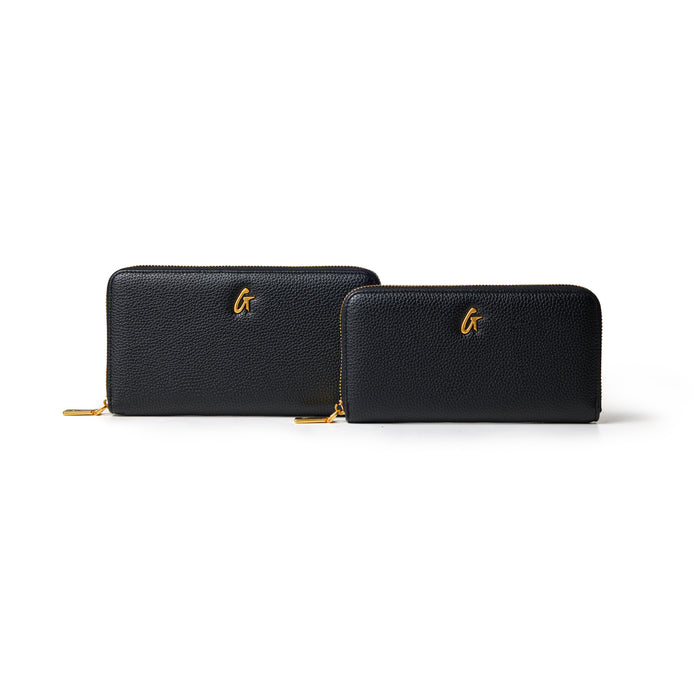 Black pebble leather wallets with gold zipper and "G" logo, one larger and one smaller, on a white background.