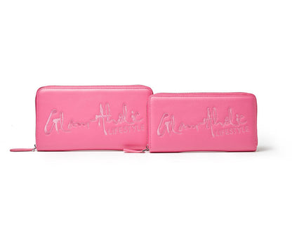Pink wallet and clutch with "Glamathic Lifestyle" embroidered in script on the front.