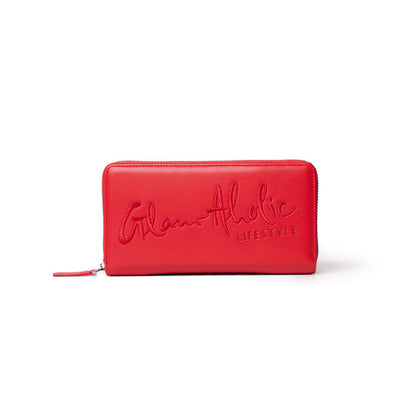 Red wallet with embossed "Glam-Aholic Lifestyle" logo, zip-around closure, stylish and spacious for essentials.