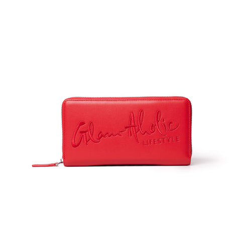 Red wallet with embossed "Glam-Aholic Lifestyle" logo, zip-around closure, stylish and spacious for essentials.